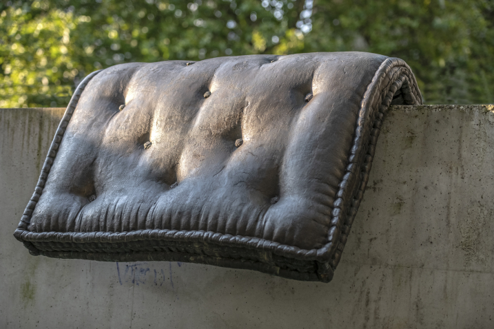 Image of a fountain sculpture by Tatiana Trouvé. The sculpture consists of a bronze cast of a mattress placed on a concrete base.