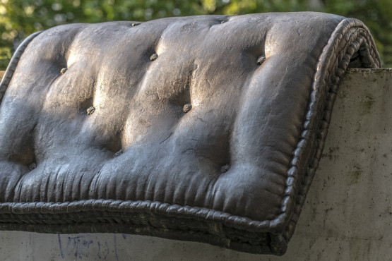 Bild einer Brunnenskulptur von Tatiana Trouvé. Die Skulptur besteht aus einem Brozeguss einer Matratze, die über einen Betonsockel gelegt ist.